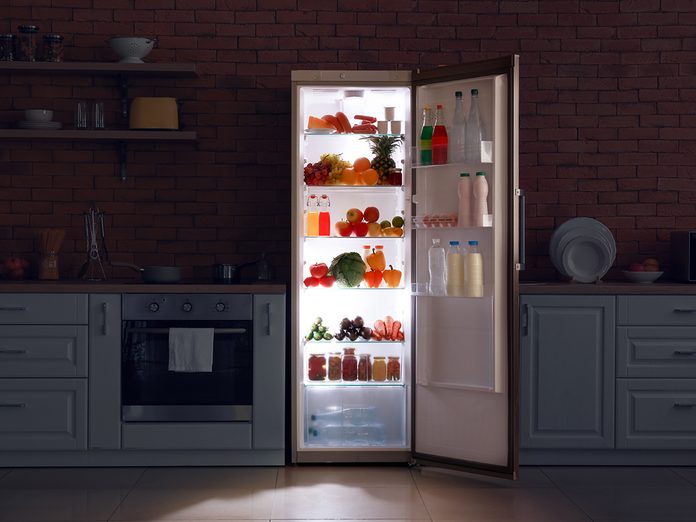 what to do during a power outage - Open refrigerator in dark modern kitchen