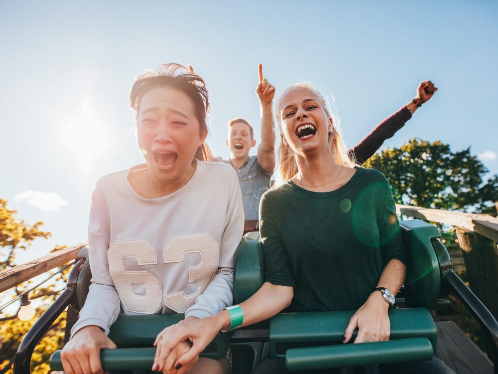 Two female friends riding a rollercoaster