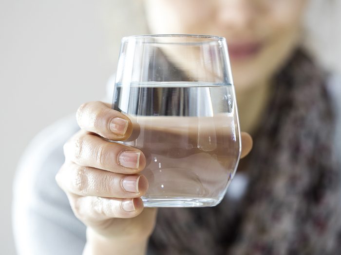 Benefits of staying hydrated - woman drinking glass of water