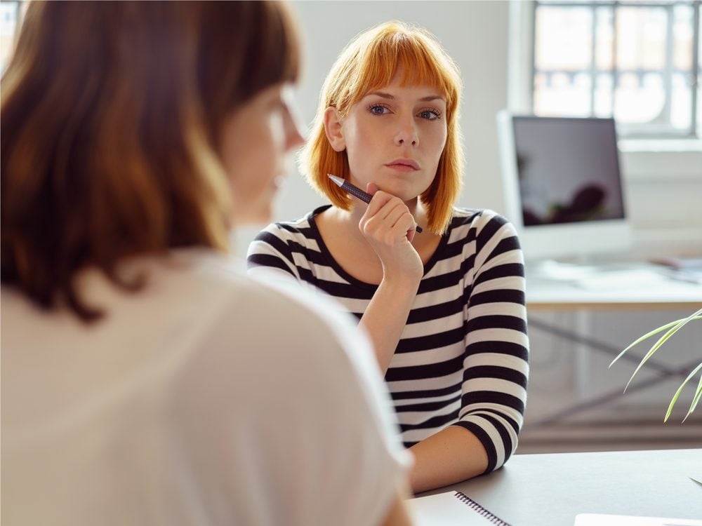 Female coworker suspicious of her colleague during team meeting