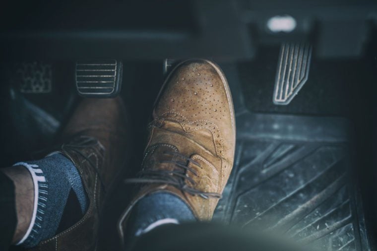 Man's foot on car pedal