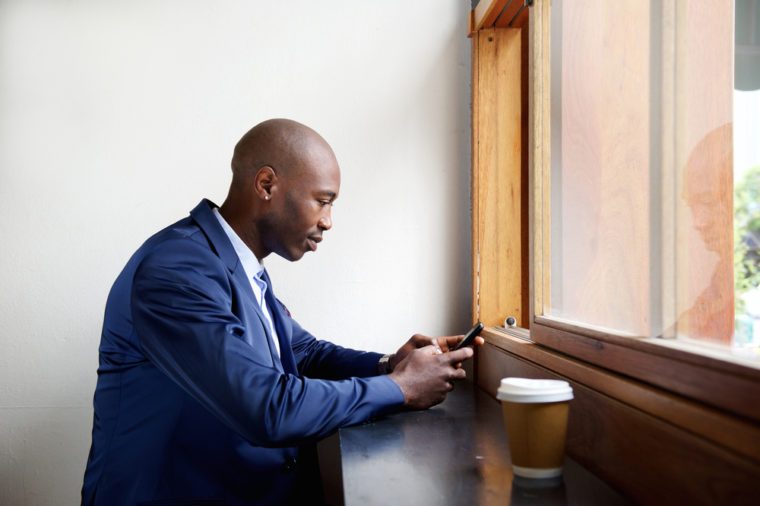 Man texting at cafe