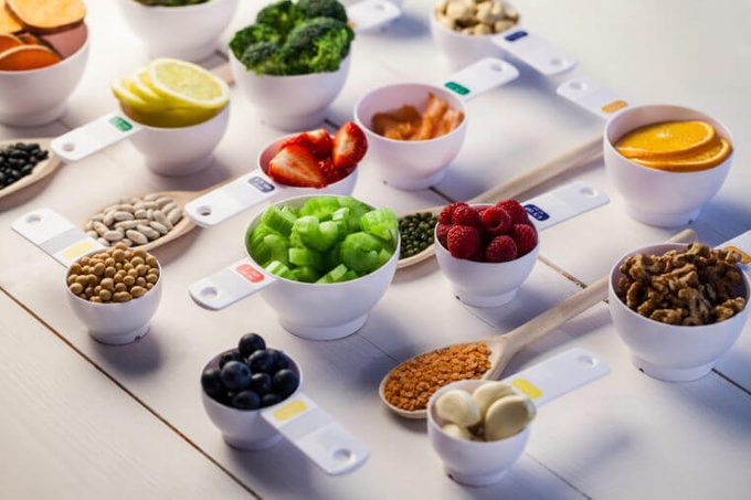 Portion cups of healthy ingredients on wooden table