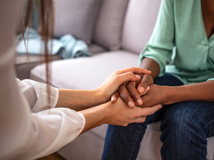 Reader's Digest dementia - African psychologist hold hands of girl patient, close up. Teenage overcome break up, unrequited love. Abortion decision. Psychological therapy, survive personal crisis, individual counselling concept