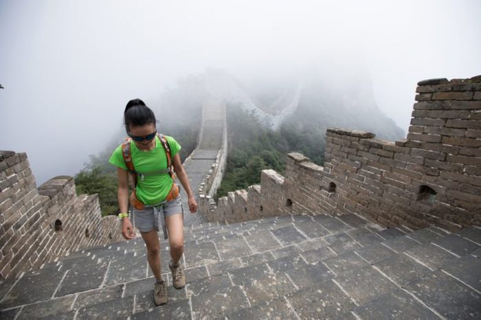 young woman hiker hiking on great wall
