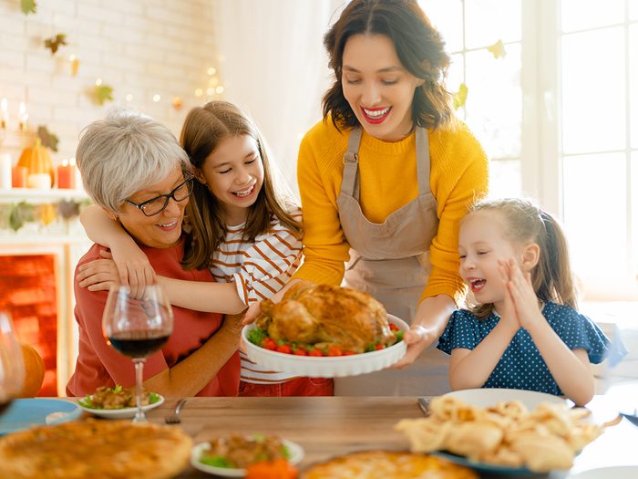 Thanksgiving celebrations around the world - Happy Thanksgiving Day! Autumn feast. Family sitting at the table and celebrating holiday. Traditional dinner. Grandmother, mother and daughters.
