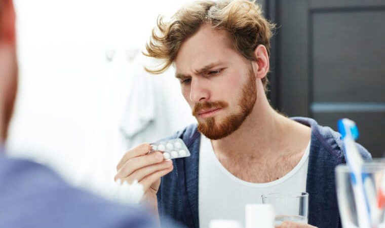 Man with headache going to take pill