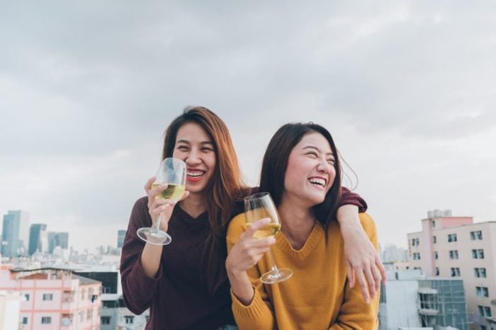 Happy asia girl friends enjoy laughing and cheerful sparkling wine glass at rooftop party,Holiday celebration festive,teeage lifestyle,freedom and fun.lesbian couple