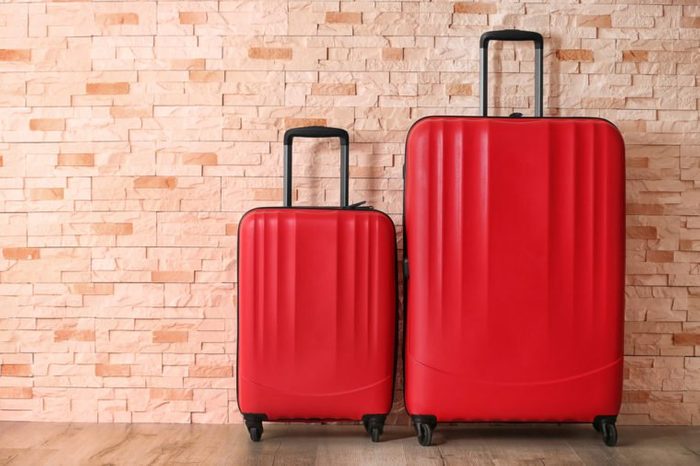 Red suitcases on brick wall background