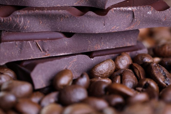 Fresh roasted coffee beans and stack of brown chocolate