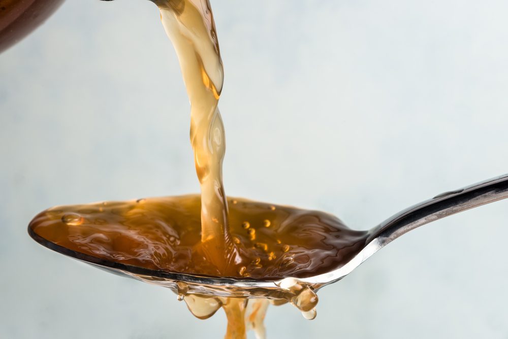 Apple cider vinegar being poured onto a spoon