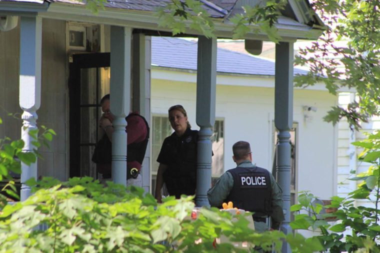 Police officers on porch of home