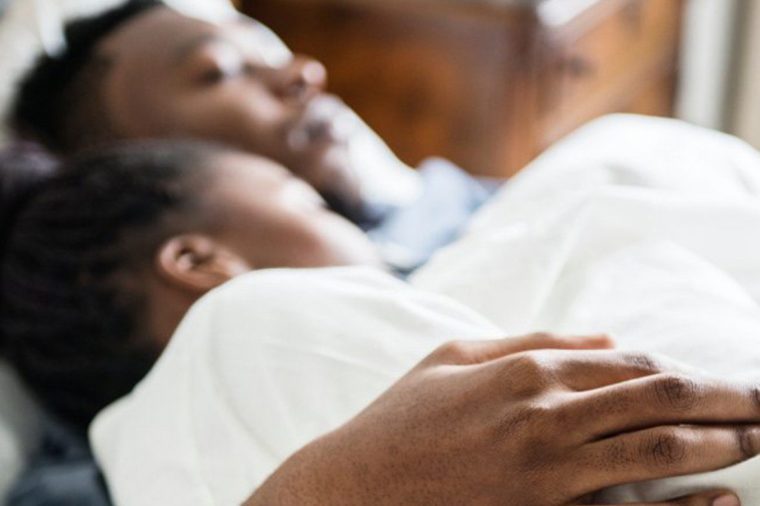 African-American couple sleeping in bed together