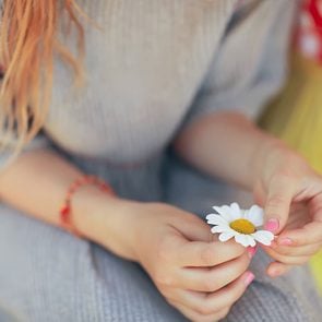 Woman's hand holding chamomile flower