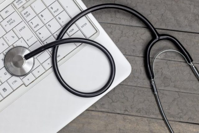 top view of stethoscope with record information paper and Laptop