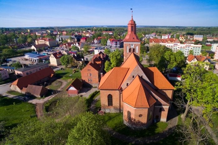 Aerial view of Wegorzewo town, Poland (former Angerburg, East Prussia). Gothic style St. Peter and St. Paul's Church on the right