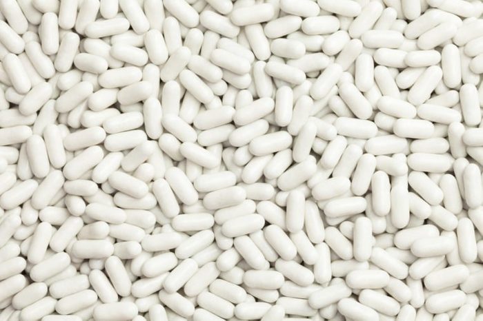 Pile of many white drug pills laying in a pile
