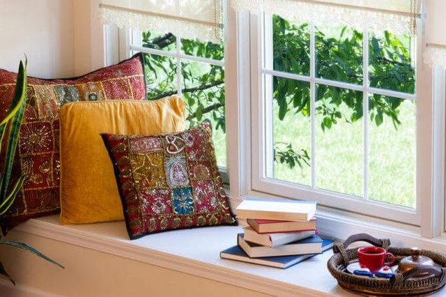 Cup of Coffee on a Tray, Piled Books and Square Pillows at the Reading Corner Inside the House.