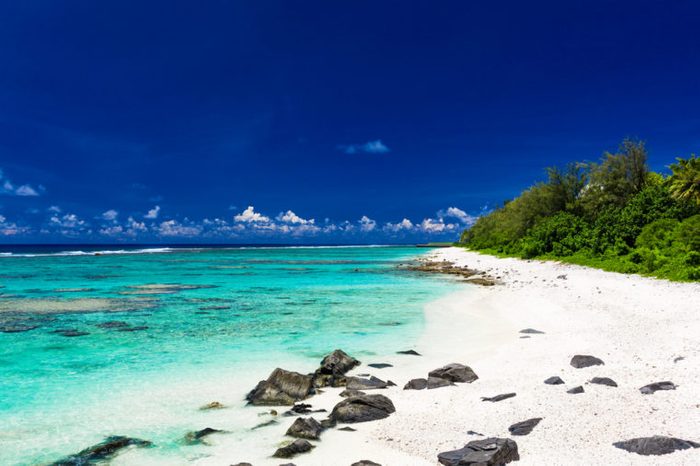 Amazing beach with white sand and black rocks on Rarotonga, Cook Islands