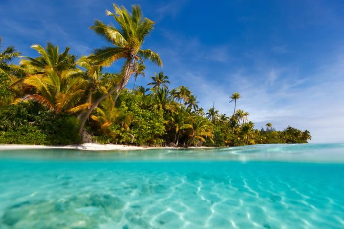 Stunning One Foot island in Aitutaki, tropical island with palm trees, white sand, turquoise ocean water and blue sky at Cook Islands, South Pacific