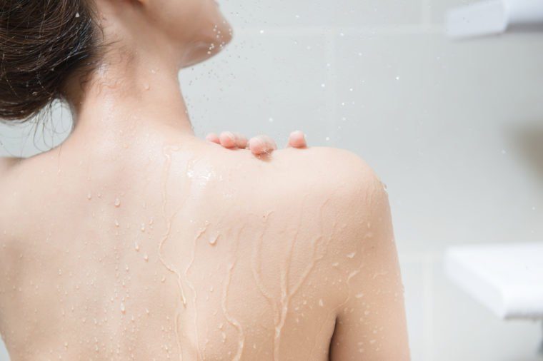 Beautiful girl washing her body shower gel