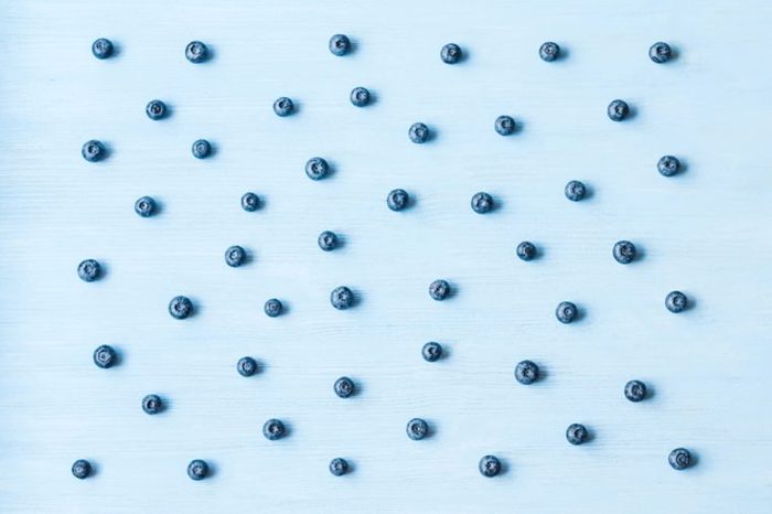 Pattern of blueberry on wooden blue background. Top view, flat lay