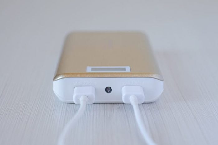 Golden power bank for mobile phone with a usb cable. Close-up