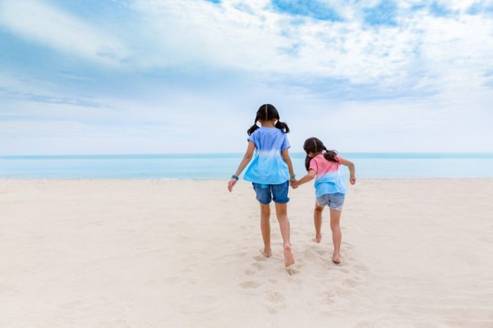 Two Asian sister enjoy playing on beach, Two little asian girls enjoy playing and walk on beach in day time,Two asian little girls enjoy playing on nice beach