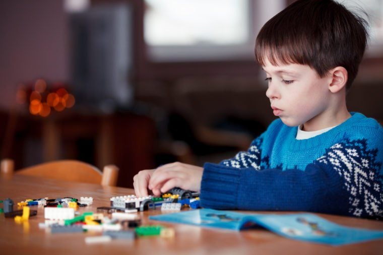 Five years old boy playing with building blocks, first education role lifestyle