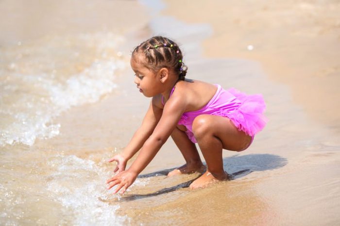 Happy young girl playing in the waves