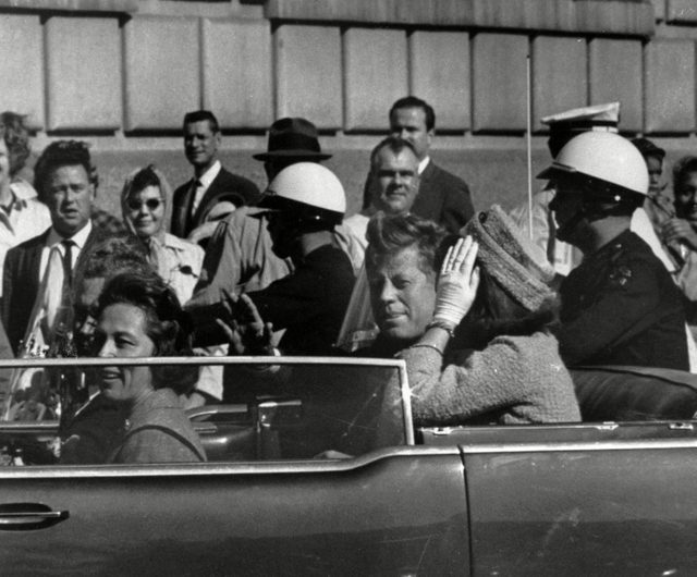 President John F. Kennedy riding in motorcade with first lady Jacqueline Kenndy