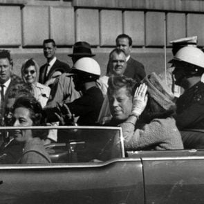President John F. Kennedy riding in motorcade with first lady Jacqueline Kenndy