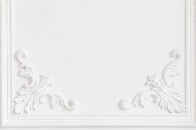The white wall is decorated with exquisite elements of plaster moldings