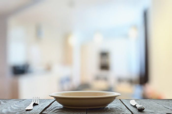 empty plate with fork and knife on wooden table in the living room