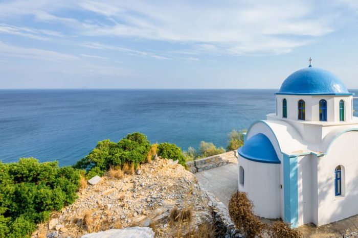 Holy white blue greek church shining over Ikaria island at the mediterranean sea sourrounded by beautiful landscape and magical bays, Ikaria, Greece