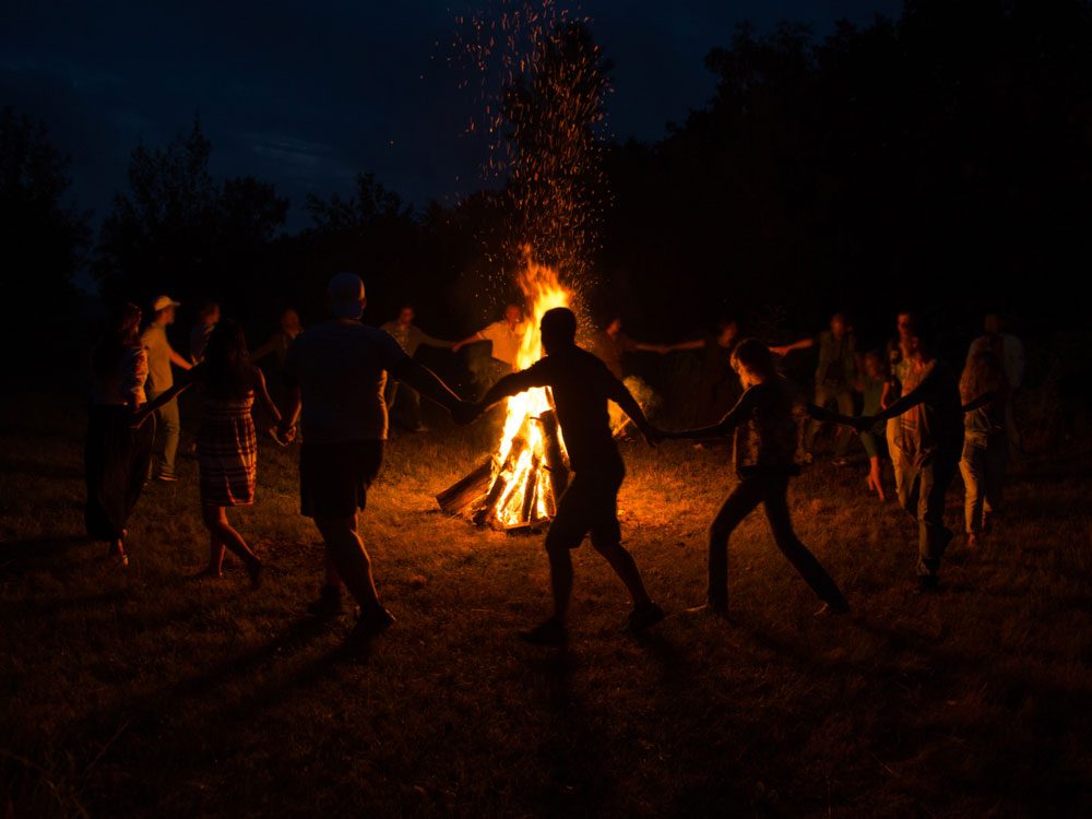 Group dance around giant bonfire