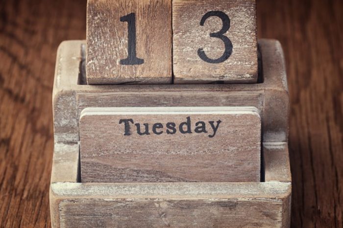 Grunge calendar showing Tuesday the thirteenth on wood background