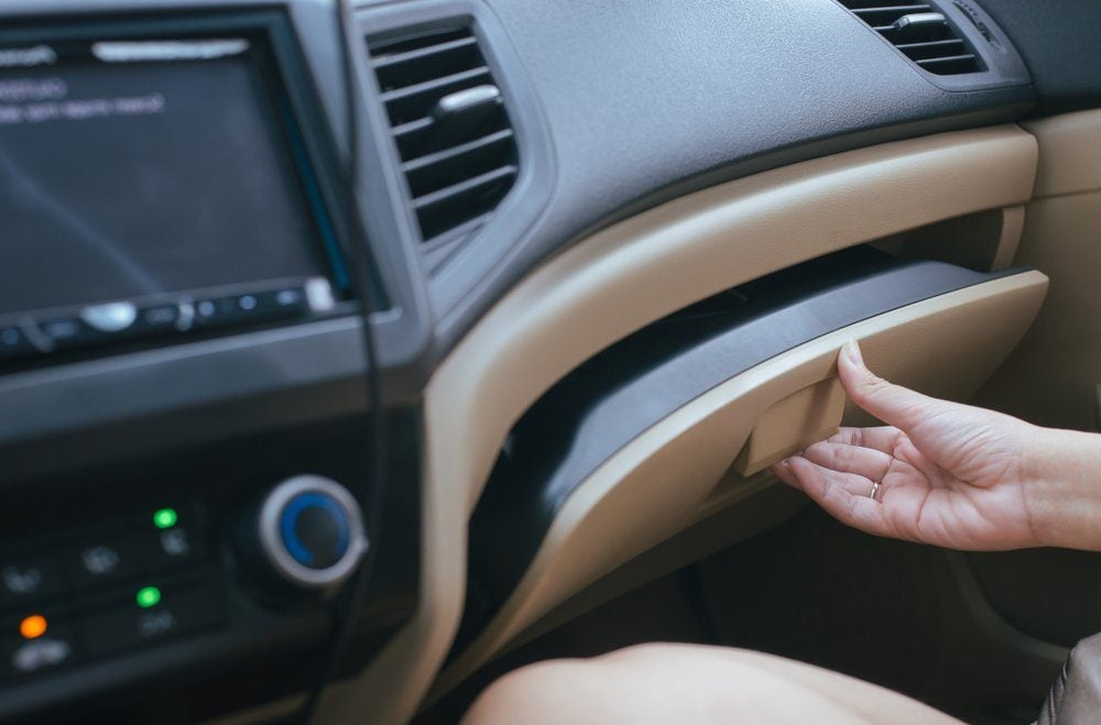 Hand open glove compartment box inside modern car