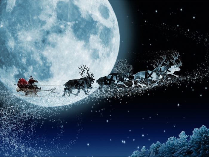 Santa and reindeer in front of moon