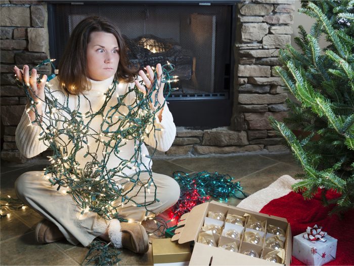 Woman untangling Christmas lights