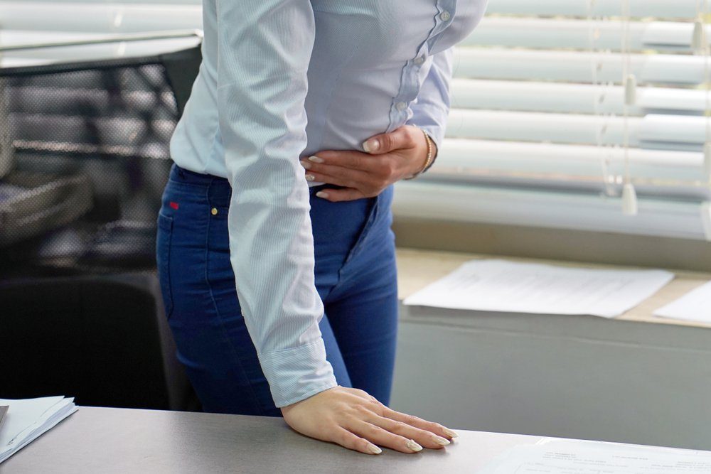 Close-up office worker Woman having painful stomachache. Chronic gastritis. Body And Health Care Concept.