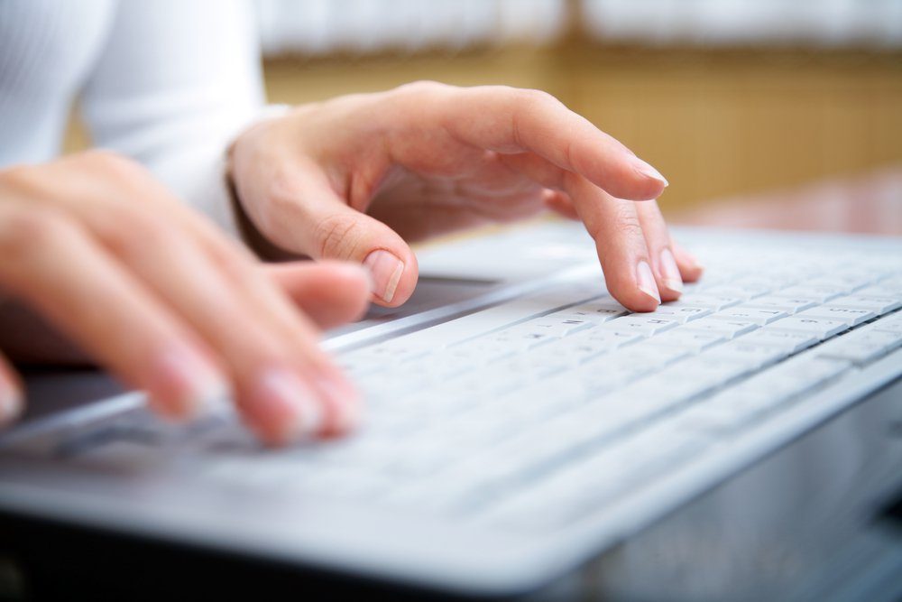 Female hands typing on a laptop