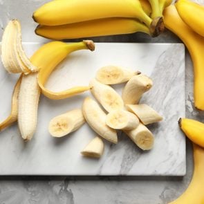 Marble board with sliced bananas on table