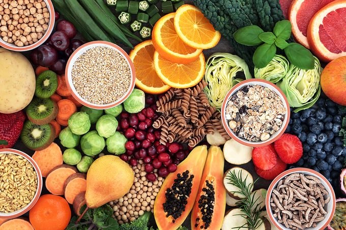 Health food concept for a high fiber diet with fruit, vegetables, cereals, whole wheat pasta, grains, legumes and herbs. Foods high in anthocyanins, antioxidants, smart carbohydrates and vitamins.
