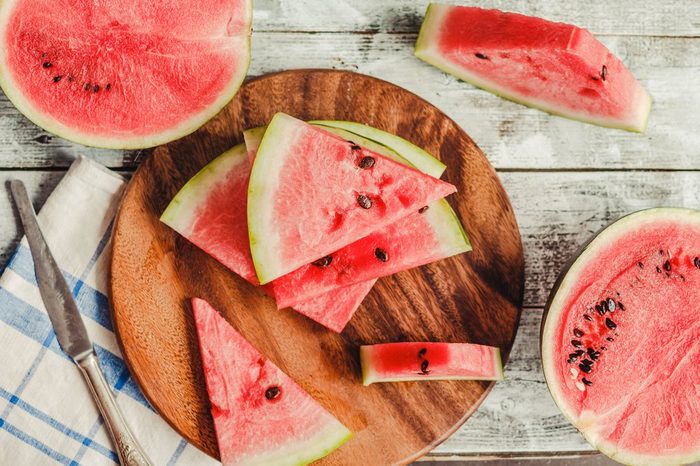 Watermelon slice on a blue rustic wood background.Summer fruit, raw food concept. Top view.