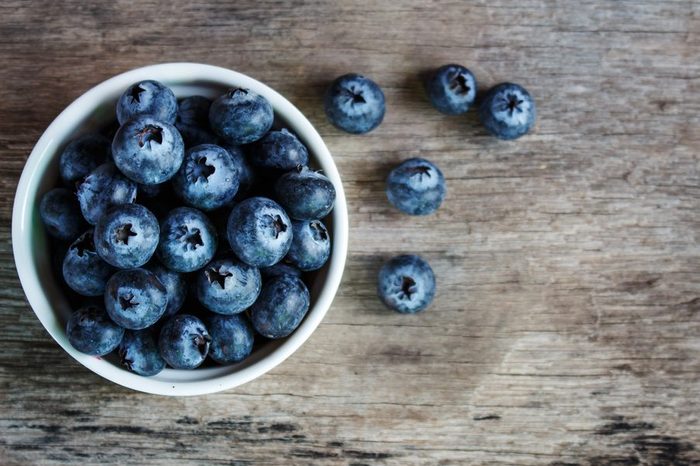 Blueberries in a white bowl on a wooden table