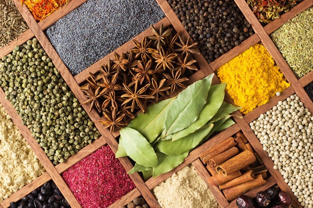 Spices and herbs for decorating food labels . Seasoning in wooden box as background, top view.