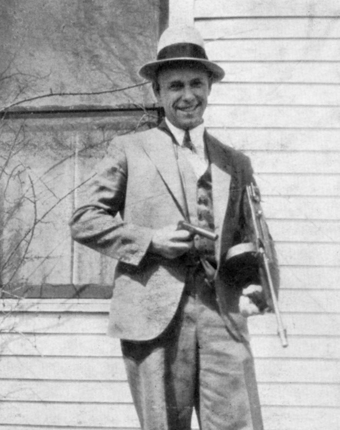 VARIOUS John Dillinger (1903-1934), American Gangster, Portrait holding Toy Gun Used to Escape Jail in Crown Point, Indiana, USA, 1934