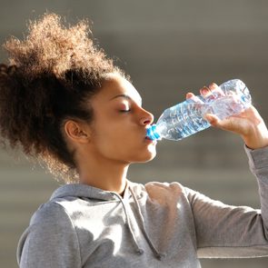 Attractive young woman drinking water from bottle