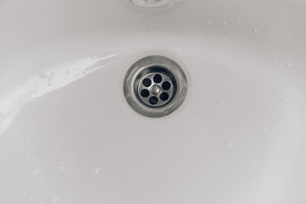 Drain water in the white sink in the bathtub
